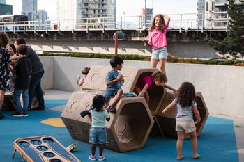 Children playing on a playground with a large structure.